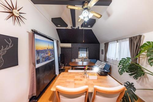 a living room with a table and a couch at NOT A HOME亀有 駅徒歩5分 無料駐車場 ディズニーまで車22分 羽田空行バス直通 90m2 in Tokyo