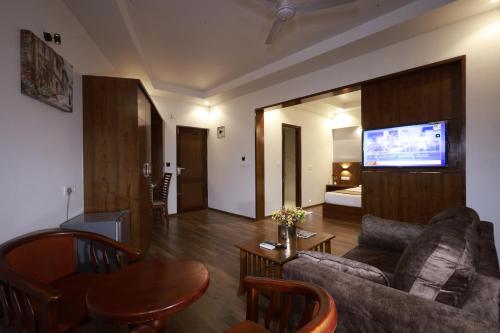a living room with a couch and a tv at Metro Plaza Hotel by RAK Rooms, Mangaluru in Mangalore