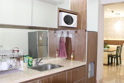 ジャカルタにあるApartment Ambassador 2 Kuninganのシンクと電子レンジ付きのキッチン