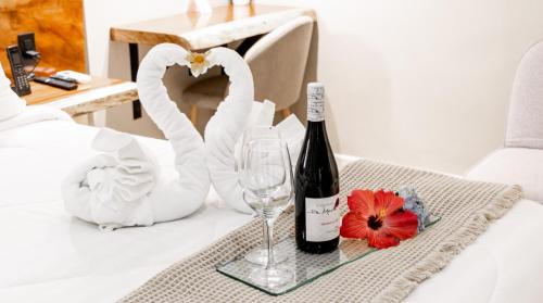 a bottle of wine and a glass on a table with swans at Hotel Boutique Los Abetos in Boquete