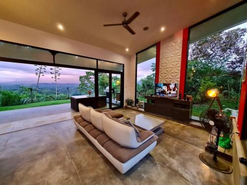 a living room with a couch and large windows at luxury contemporary jungle villa in Quepos