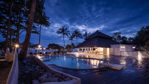 a pool at a resort at night with palm trees at Moonlight Bay Resort in Ko Lanta