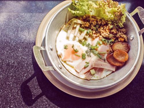 a bowl of soup with meat and vegetables on a table at Tantai Eco Farm Stay At Khao Yai in Ban Sap Noi
