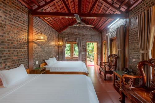 a bedroom with two beds and a brick wall at Ninh Binh Family Homestay in Ninh Binh