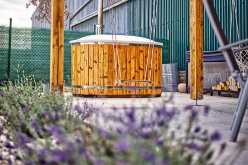 a wooden swing in a garden with purple flowers at Vila Ochutnej Pálavu in Pavlov