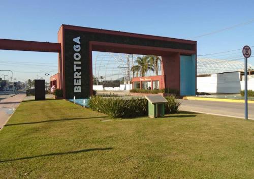a sign for a gas station with a bench in the grass at Suítes Para Casal in Bertioga