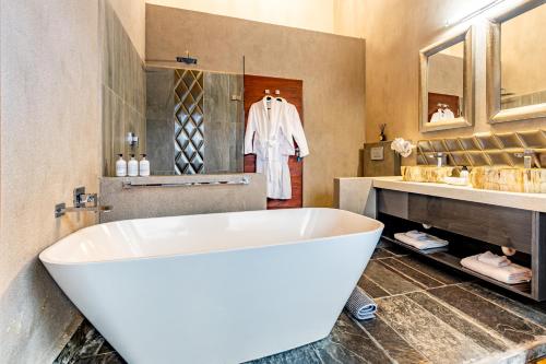 a bathroom with a large white tub and a sink at Kusudalweni Safari Lodge and Spa in Guernsey Nature Reserve