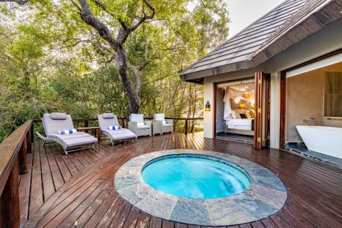 a pool on a deck with a bathtub and chairs at Kusudalweni Safari Lodge and Spa in Guernsey Nature Reserve