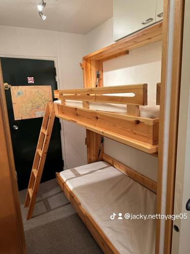 Ce lit superposé se trouve dans un dortoir avec une échelle. dans l'établissement Chez Martine, à Vars