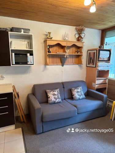 un salon avec un canapé bleu dans une pièce dans l'établissement Chez Martine, à Vars