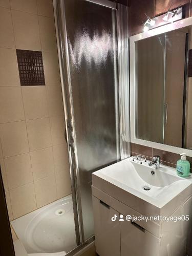 une salle de bain avec un lavabo et une douche dans l'établissement Chez Martine, à Vars