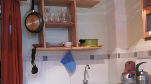 a kitchen with a shelf on the wall at Casa De Mama Cusco - The Treehouse in Cusco
