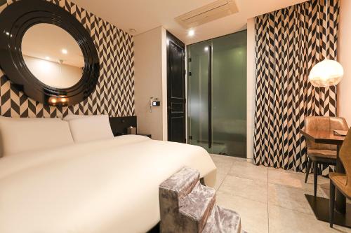 a bedroom with a large white bed and a mirror at Hotel The Designers Cheongnyangni in Seoul