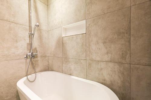 a bathroom with a white tub and a shower at Hotel The Designers Cheongnyangni in Seoul