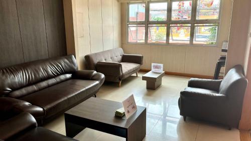 a living room with couches and chairs and a table at Fortune Surin Hotel in Surin