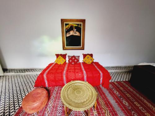 a red bed with four cats on top of it at Riad Dar Nawfal in Sale