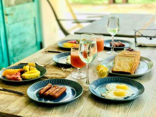 a wooden table with plates of food and glasses of wine at Mawella House 1807, Tangalle in Tangalle