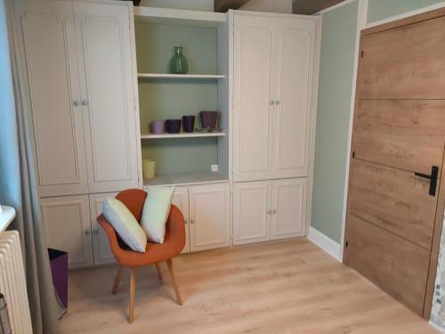a living room with a chair and a closet at Le PTit Atelier, Appartement cosy à Champagnole in Champagnole