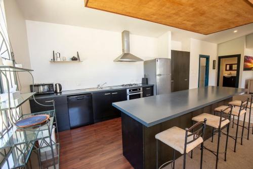 a kitchen with a large counter and stools in it at Casa Del Caird in Methven