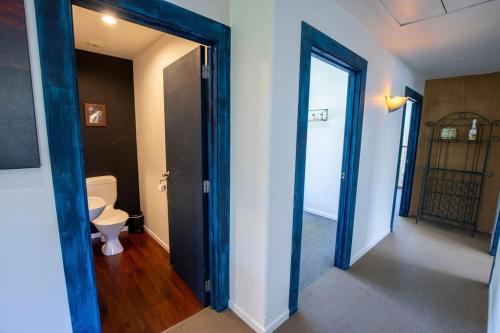 a hallway with a bathroom with a toilet and an open door at Casa Del Caird in Methven