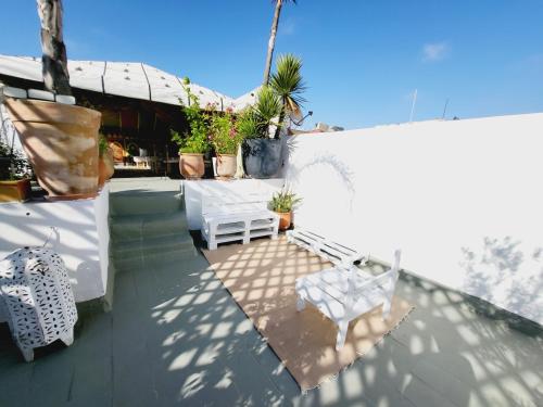 a patio with two white chairs on a roof at Riad Dar Nawfal in Sale