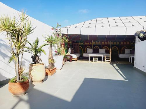 a patio with potted plants and a pavilion at Riad Dar Nawfal in Sale