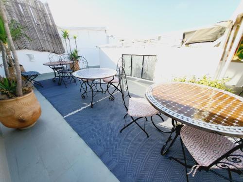 a patio with tables and chairs on a balcony at Riad Dar Nawfal in Sale
