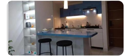 a kitchen with a blue counter and stools in it at 'Savitham' City View flat in Trivandrum in Trivandrum