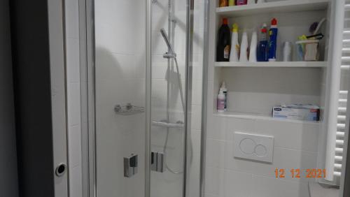 une douche avec une porte vitrée dans une salle de bain dans l'établissement Le Tavaillon, au Grand-Bornand