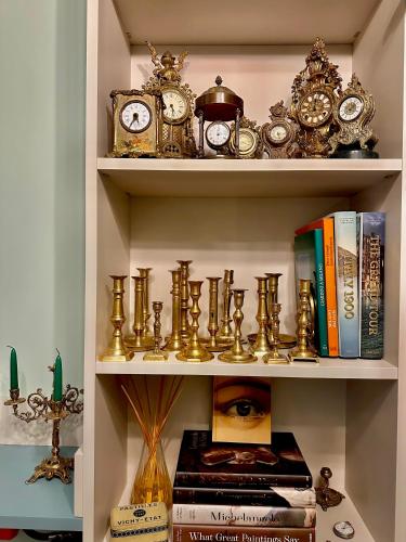 a book shelf filled with clocks and books at Fontana 16 Rooms in Milan