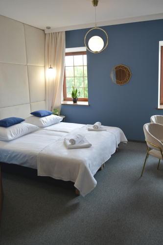 two beds in a room with blue walls at Noclegi Zakład Aktywności Zawodowej w Świerzawie in Świerzawa