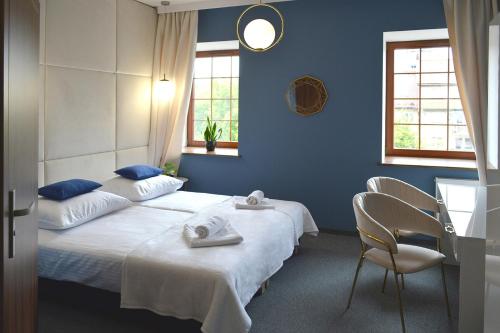 a blue bedroom with a bed and a chair at Noclegi Zakład Aktywności Zawodowej w Świerzawie in Świerzawa