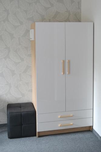 a white cabinet with a black stool next to it at Noclegi Zakład Aktywności Zawodowej w Świerzawie in Świerzawa