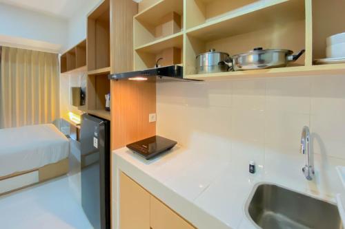 una cocina con fregadero y encimera en Nice and Compact Studio at Tokyo Riverside PIK 2 Apartment By Travelio, en Rawalembang