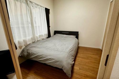 a small bed in a room with a window at 302便利な立地札幌駅が徒歩7分の超人気で美室女性に人気 in Kita-rokujō