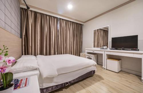a hotel room with a bed and a desk at Apple Hotel in Jeju