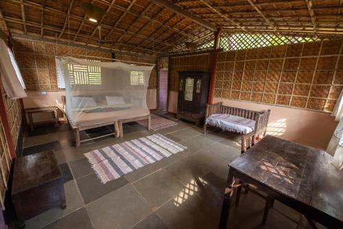 a bedroom with a bed and a table in a room at Khaama Kethna Eco Sustainable Village in Agonda