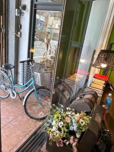 a bike parked in front of a store window with flowers at Good Farming Day B&B in Chishang