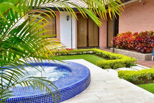 a garden with a blue pool in front of a house at Hotel Jade Spa in Santa Rosa de Cabal