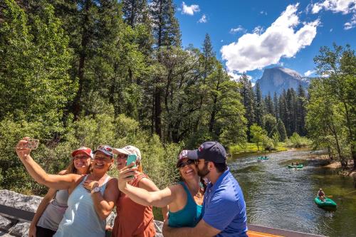 a group of people posing for a picture while rafting down a river at Evergreen Lodge at Yosemite in Groveland