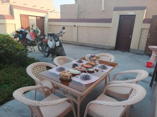 a table and chairs with food on top of it at Shodlik Guest House in Khiva