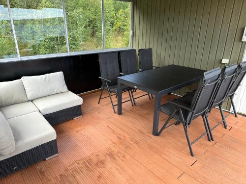 a room with a table and chairs and a couch at En perle på Gjøvik, nær populær strand ved Mjøsa in Gjøvik