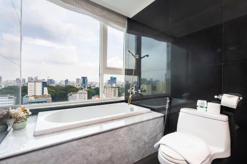 um banheiro com banheira e janela em Leman Luxury Apartments 2BR 3BR For Rent In Central em Cidade de Ho Chi Minh