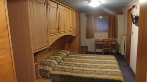 a bedroom with a bed with a cabinet above it at Hotel Pordoi - Fam Furgler in Arabba