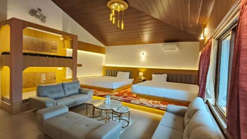 a hotel room with two beds and a couch at Urmilaa Green County Resort 35 KM From Kolhapur in Kolhapur