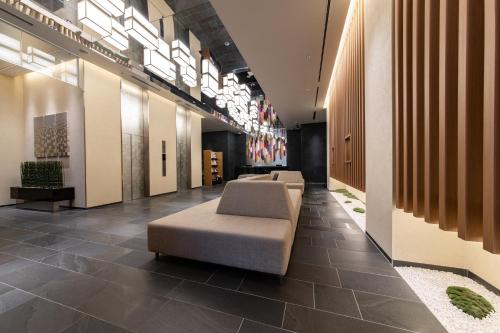 a lobby with a couch and chairs in a building at Hotel Vista Kanazawa in Kanazawa