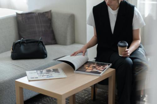 a woman sitting on a couch next to a coffee table at Hotel Vista Kanazawa in Kanazawa