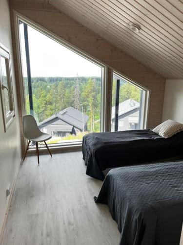 a bedroom with two beds and a large window at Villa Jämsä in Säyrylä