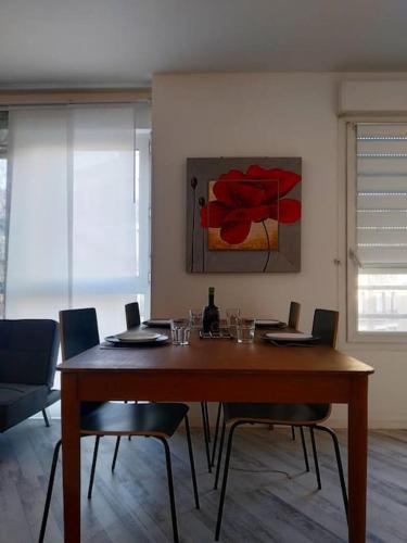 une table de salle à manger avec des chaises et un tableau au mur dans l'établissement Superb modern apartment, à Clichy