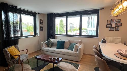 un salon avec un canapé et une table dans l'établissement Séjour confort à PARIS La Défense Arena, à Nanterre